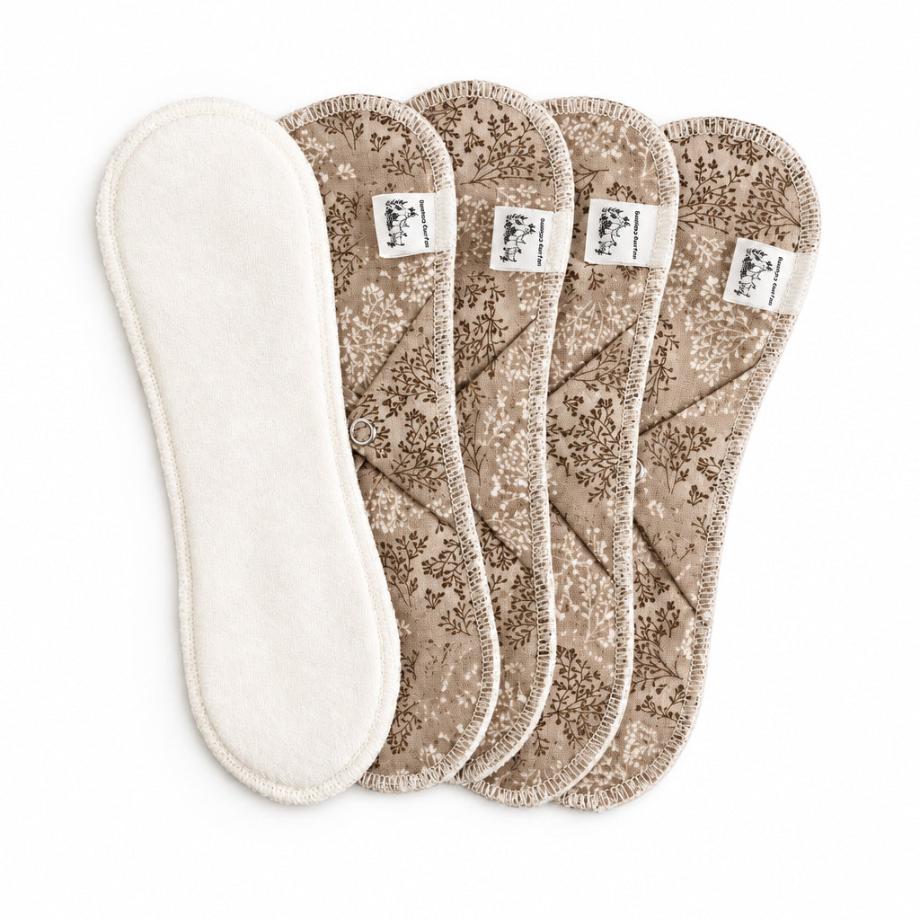 Serviettes sanitaires bambou et coton longue de 9 1/4 pouces, soit  23.5 cm. Le dessus est de bambou et coton. Le dessous est de motif de petites branches avec des feuilles et des fleurs miniatures dans les tons de beige.